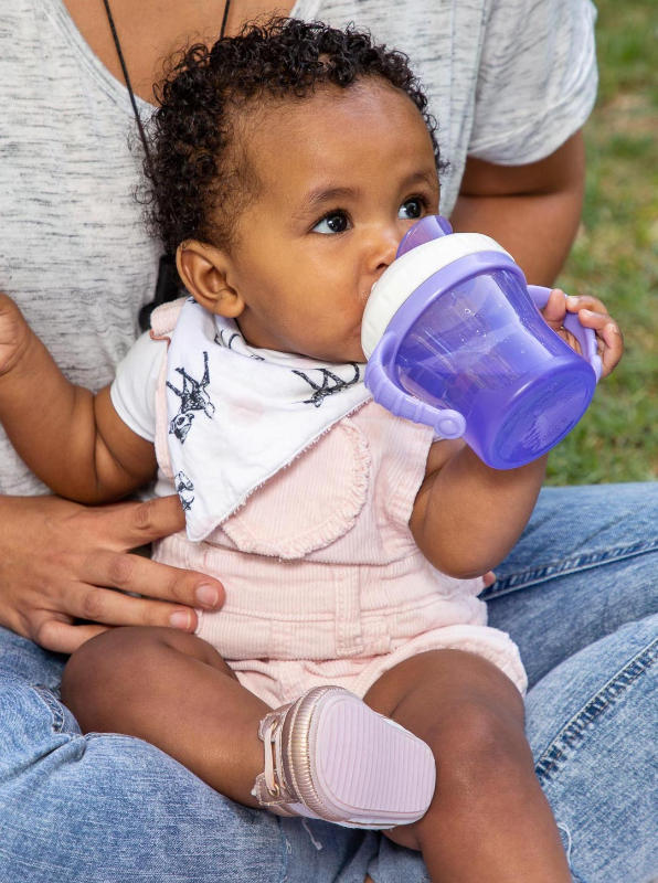  A toddler using A sippy Cup  that converts into a straw cup and snack cup. It features a retractable lid for easy storage, removable handles for customizable grip, and a soft silicone spout and straw for gentle sipping.